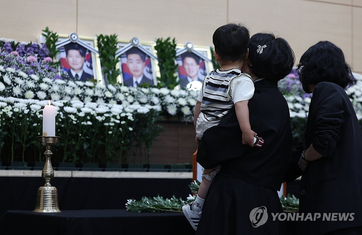 30일 경북 포항시 남구 해군 항공사령부 체육관에 마련된 '해군 P-3CK 917호기 순직자 합동분향소'에서 순직 해군의 유족과 어린 아들이 헌화하고 있다.