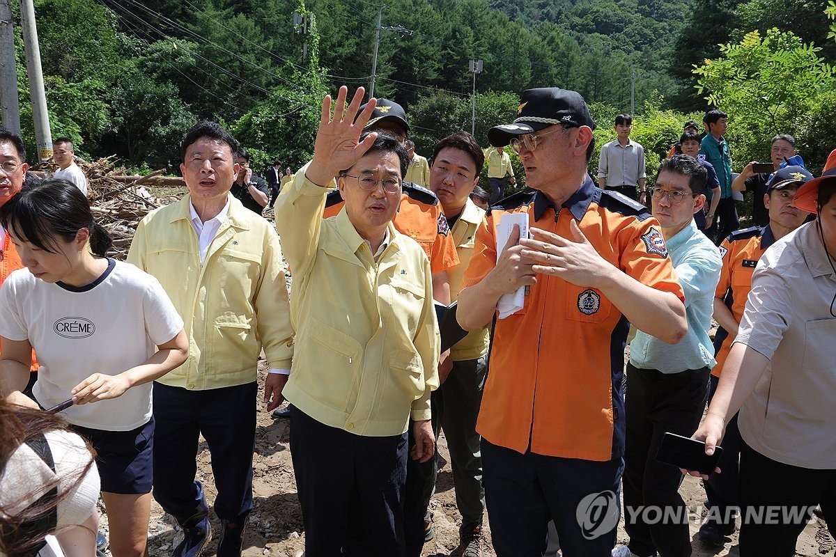김동연 경기도지사(가운데)가 22일 오후 경기도 가평군 조종면 마일리에서 수해 현장을 살펴 보며 소방 관계자와 대화를 나누고 있다.